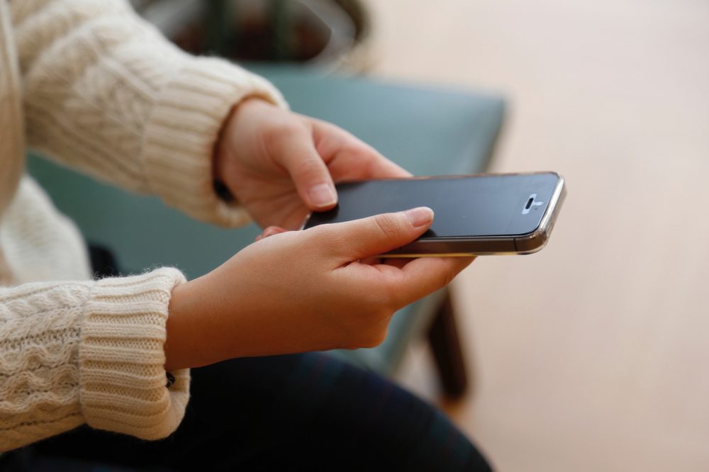 スマホを手に持って操作する様子